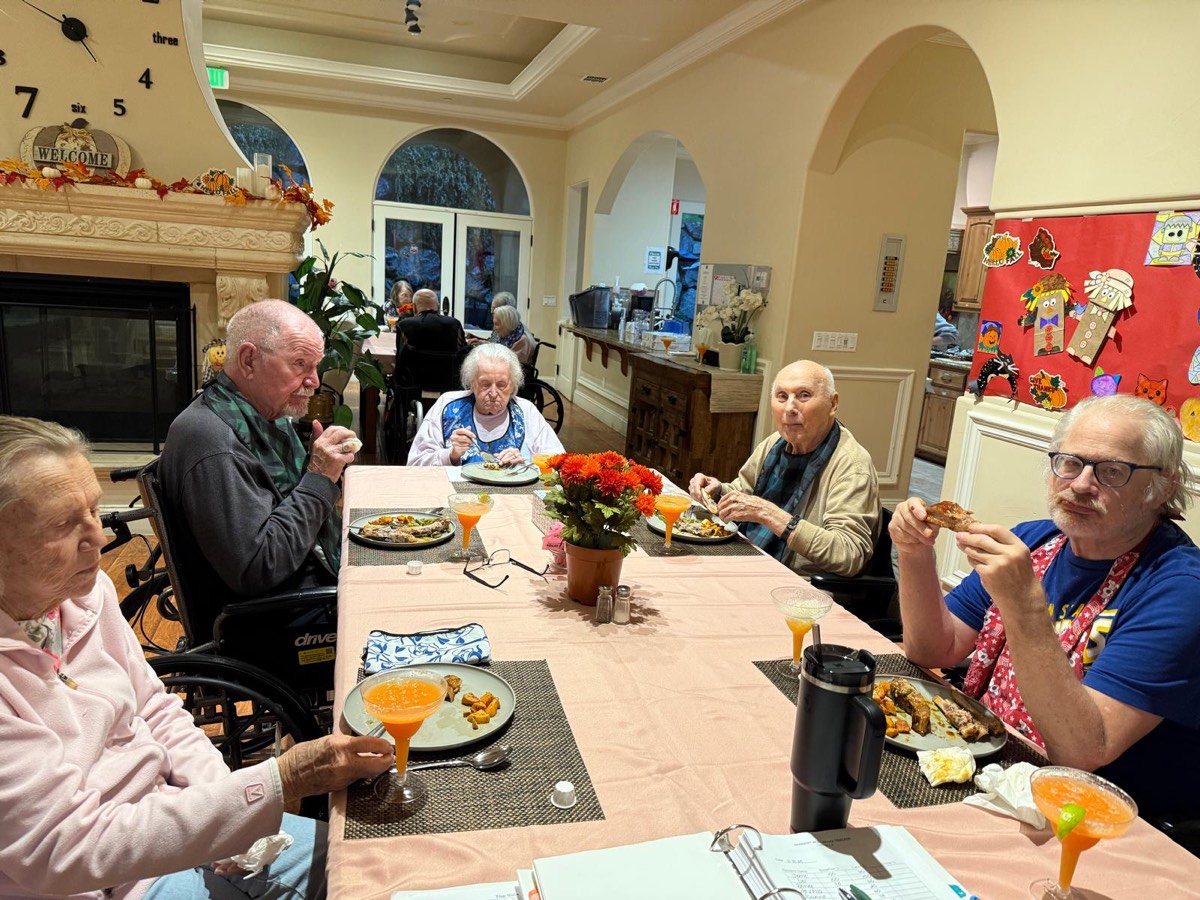 Residents sharing a meal and drinks at the dining table